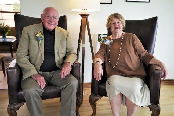 Jim & 南希·本森坐在波士顿州立大学大卫·帕克之家的椅子上.